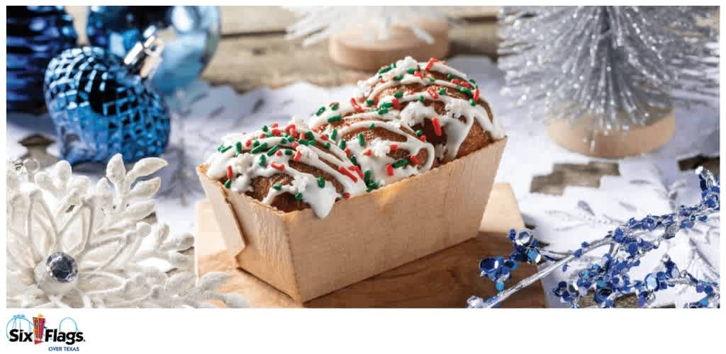 Festive cake with icing and sprinkles surrounded by winter-themed decorations.