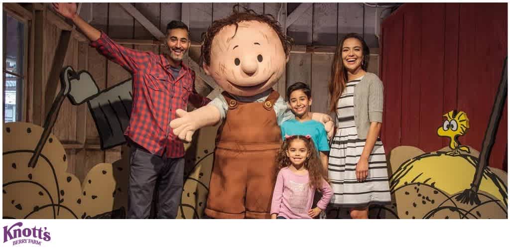 Group posing with Charlie Brown at Knott's Berry Farm in a rustic setting.
