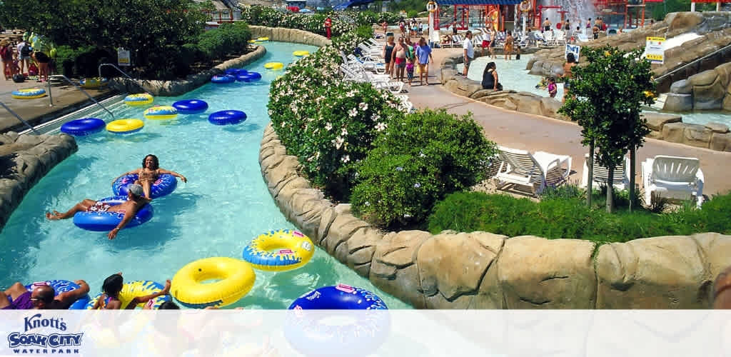 People enjoying a lazy river at Knott's Soak City Water Park with floating tubes and lush greenery surrounding the area