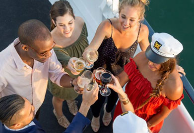 Description: This image captures a cheerful group of five adults onboard a boat, engaging in a toast. They are standing closely together, viewed from above, with their drinks raised toward the center of the frame to signify a shared celebratory moment. The individuals express joviality and companionship, each holding a unique glass with a variety of beverages. The attire of the group suggests a casual yet festive occasion, with one individual wearing a captain's hat, adding a nautical touch to the scene. The calm water surrounding the boat and the warm, natural lighting indicate that this gathering is taking place during a pleasant time of day, possibly during the late afternoon.

At GreatWorkPerks.com, we make enjoying moments like these more accessible with the promise of savings - offering the lowest prices on tickets that turn life's special occasions into memories without breaking the bank.