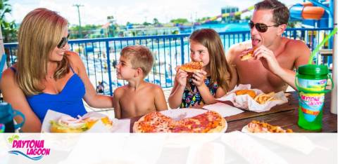 Family enjoying pizza at a sunny outdoor table with a Daytona Lagoon logo.