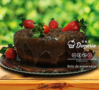 Bolo de aniversário de chocolate com recheio de brigadeiro e morangos sobre uma mesa