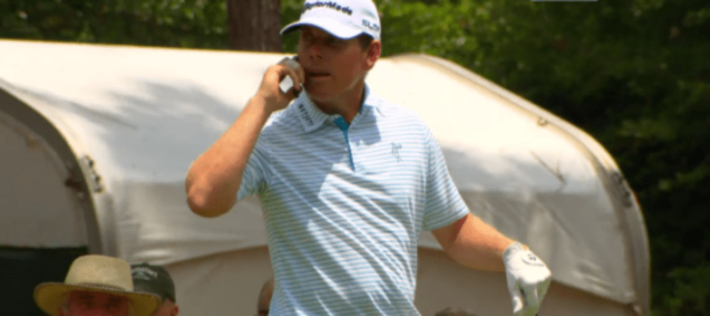 Justin Leonard telefoniert auf der Proberunde der US Open mit dem Handy eines Volunteers.