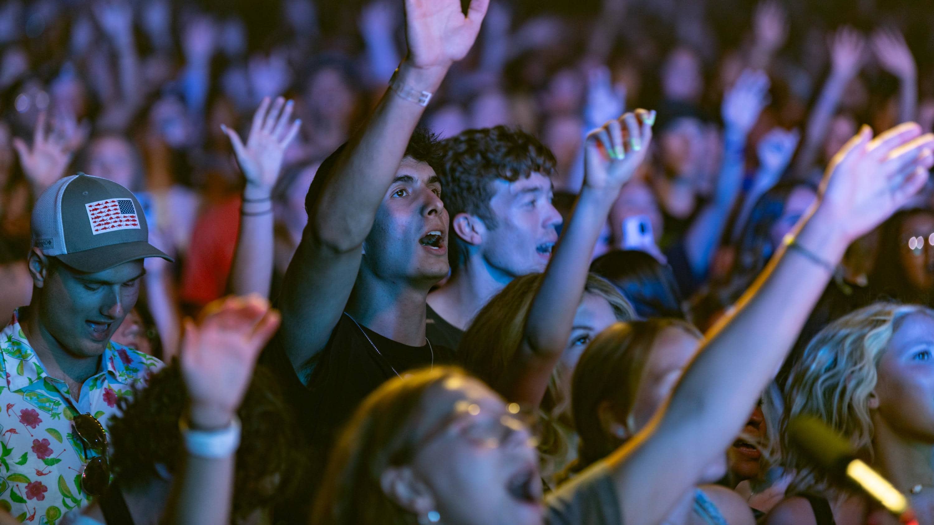 students at chapel with hands in the air