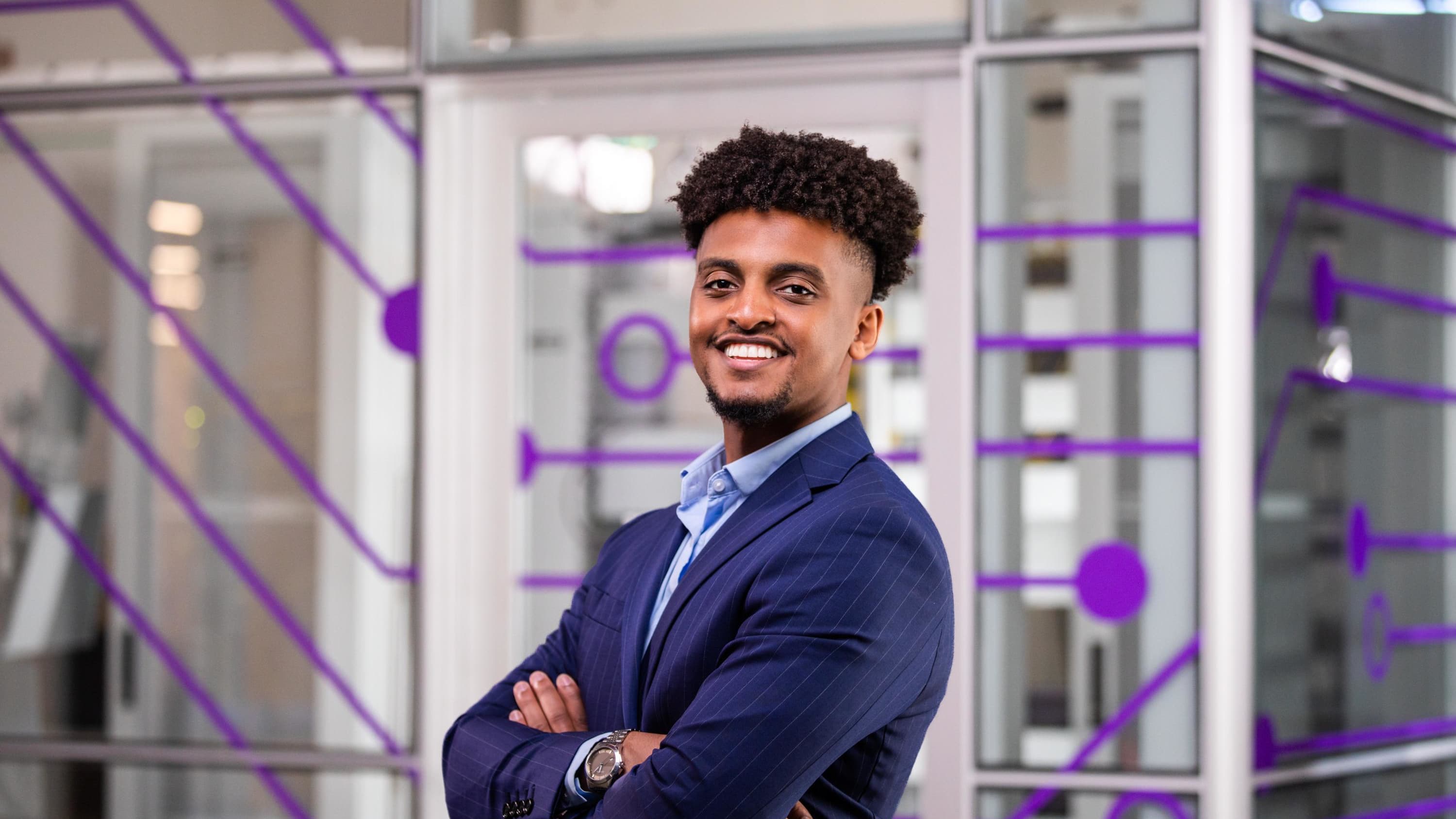 Male master's degree student smiles in front of classroom at GCU's campus