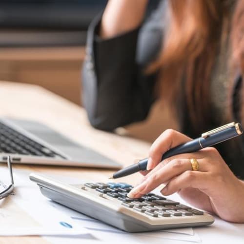 woman's using a calculator and working on laptop