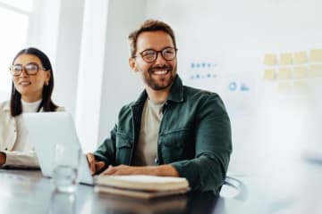 A man and woman working and smiling