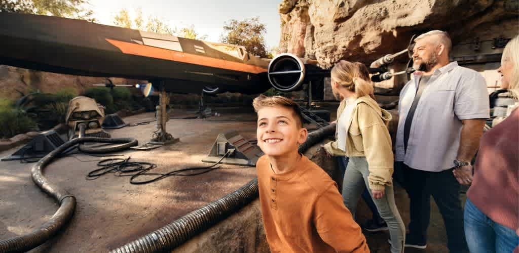 A family admires a Star Wars vehicle, showcasing their excitement and interest in the iconic sci-fi franchise.