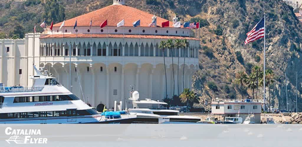 A waterfront scene with a large white building with a dome, boats, and an American flag.