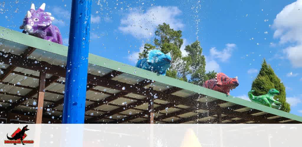 Colorful dinosaur sculptures on a roof with water droplets in the foreground.