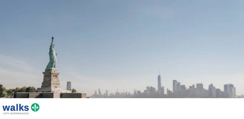 A wide view of the Statue of Liberty with New York City skyline in the background under a clear sky