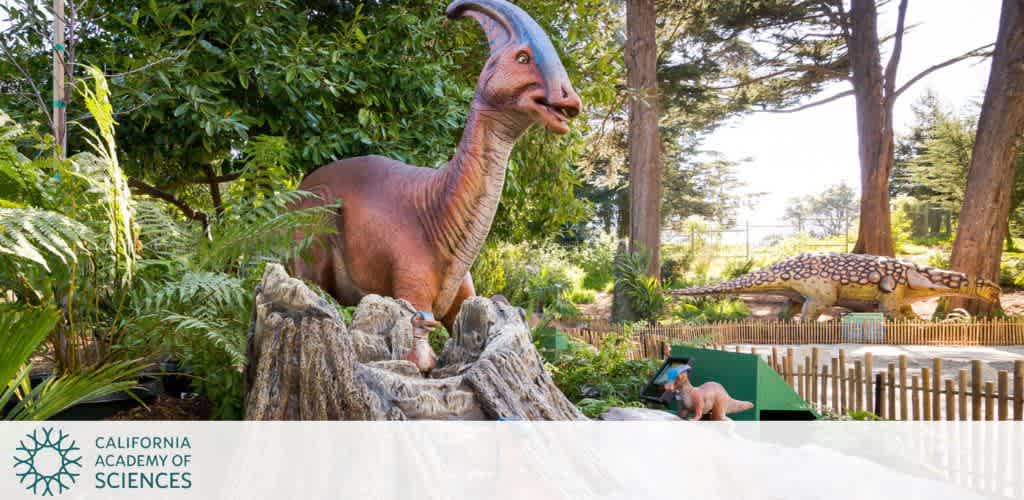 Life-sized dinosaur models in an outdoor exhibit with lush greenery at the California Academy of Sciences.
