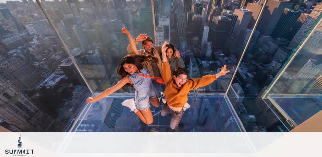 A group of four friends excitedly jump on a transparent glass floor at SUMMIT One Vanderbilt, with a dramatic view of New York City’s skyscrapers and streets far below, bathed in warm sunset light.