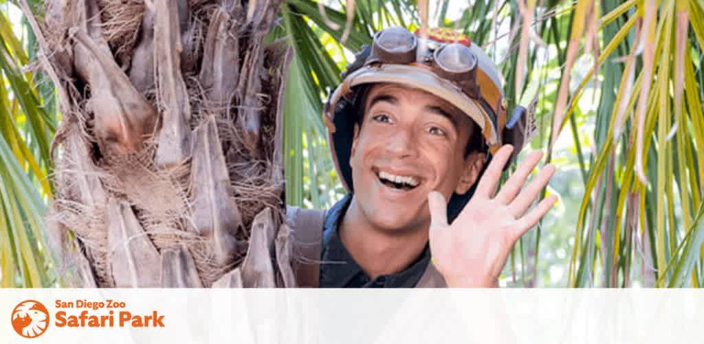 Image Description: The photograph captures a cheerful individual peering out from behind a palm tree. The person is wearing a brown, aviator-style hat equipped with goggles resting on the brim. A radiant smile accompanies a waving gesture, which contributes to the friendly and inviting atmosphere of the image. The backdrop showcases lush greenery suggestive of a tropical environment. In the foreground, a logo for the San Diego Zoo Safari Park is prominently displayed, aligning with the adventurous theme of the photograph.

Remember to check GreatWorkPerks.com for exclusive savings on tickets, ensuring you experience the thrill of the San Diego Zoo Safari Park at the lowest prices!