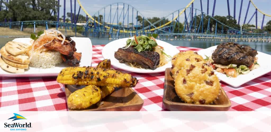 Plate of grilled corn, barbecue ribs, fried chicken, and steak with a roller coaster in the background on a red and white checkered tablecloth