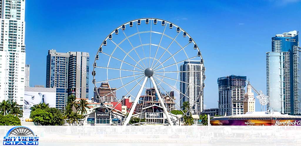 Ferris wheel with "Skyviews Miami" label amidst urban skyline under clear skies.