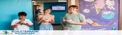 Image showing three individuals smiling and holding ice creams in a hallway with colorful wall art, including a depiction of an astronaut and a planet. Text displays Schlitterbahn Waterpark, promoting a recreational venue.