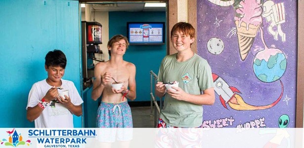 Three individuals stand smiling in a waterpark setting, enjoying ice cream. Colorful murals with space and ice cream themes adorn the wall behind them. Text at the bottom promotes Schlitterbahn Waterpark in Galveston, Texas.