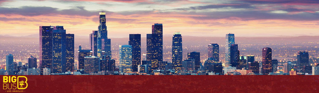 This image displays a panoramic view of the Los Angeles skyline during what appears to be either sunrise or sunset. The silhouettes of numerous skyscrapers stand tall against the sky which is painted in a gradient of warm colors, with hues of pink, orange, and purple that transition to a deeper blue. The dominant buildings gleam with scattered lights, hinting at the bustling urban life within. The foreground is overlaid with the logo and text "BIG BUS TOURS LOS ANGELES," suggesting this image is likely promotional material for a sightseeing tour company. Below the skyline, a broad red strip frames the bottom part of the image.

At FunEx.com, we're committed to ensuring that you experience the dazzling energy of Los Angeles at the lowest prices available—hop on with our exclusive discounted tickets and explore the City of Angels while enjoying significant savings!