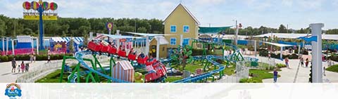 A colorful amusement park scene with a roller coaster and vibrant buildings.