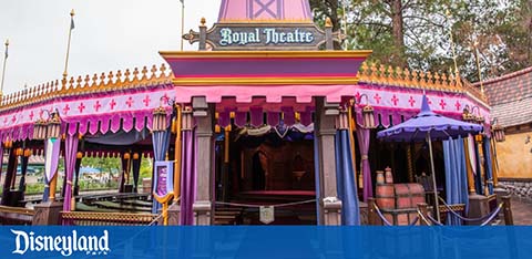 Colorful entrance of Disneyland's Royal Theatre with pink and purple hues.