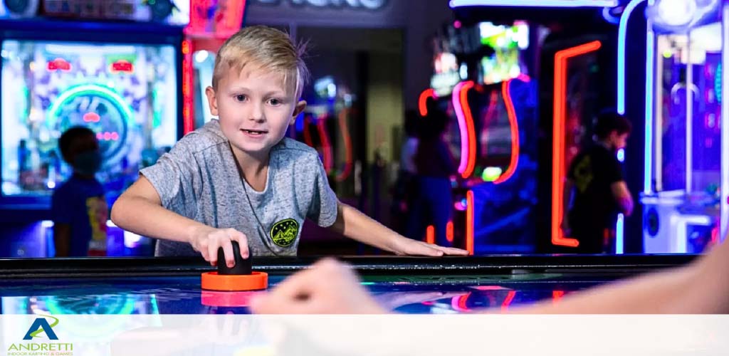 A boy plays air hockey in a vibrant arcade setting.