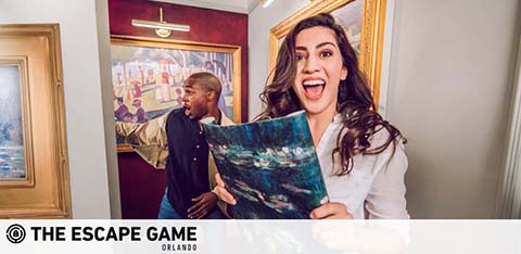 Two people with a painting, excitedly participating in an escape room game.