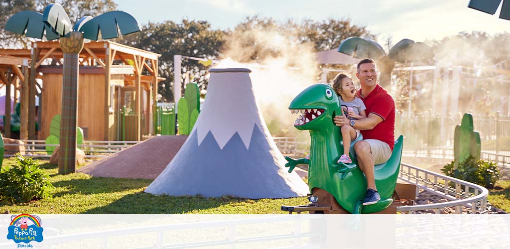 Adult and child riding a dinosaur figure at a theme park.