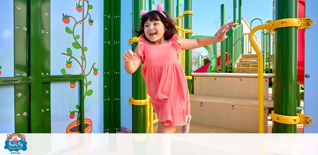 A joyful child plays on a colorful playground with slides and games.