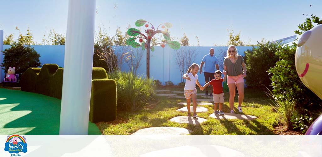 Family with two kids walking in a Peppa Pig-themed park.