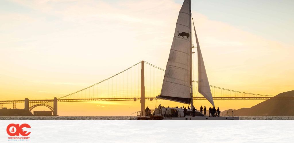 Image Description: This is a serene photograph captured at sunset, showcasing the iconic silhouette of a large sailboat with a distinctive logo on the sail foregrounded against a radiant backdrop of the setting sun. The boat is adorned with a filled sail, perfectly catching the breeze as it glides along the water. In the background, the famous Golden Gate Bridge stretches across the horizon, its profile etched into the golden-orange sky. A few individuals can be seen on the boat, enjoying the picturesque view and the tranquil sea. The warm hues of the sunset bath the entire scene in a soft, inviting glow.

Remember, when planning your next adventure, check GreatWorkPerks.com for the lowest prices on tickets to make sure you're getting the best savings while enjoying life's beautiful moments.