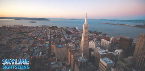 This image presents a sweeping aerial view of a bustling city during twilight, showcasing a mix of architectural styles with skyscrapers prominently rising above the urban landscape. The horizon is hazy, painted with the serene hues of the setting sun, blending warm oranges and purples with the cool blues of the sky transitioning into evening. The ocean is visible in the background along with hints of land masses at a distance, hinting at the city's coastal location. In the foreground is a prominent sharp-edged skyscraper, towering over the surrounding buildings. The lower portion of the image features the text "SKYLINE SIGHTSEEING" in bold, capitalized white letters against a dark background, indicating a touring or travel experience.

To explore this magnificent cityscape and more, visit GreatWorkPerks.com to secure your tickets at the lowest prices, ensuring memorable sightseeing adventures paired with great savings!