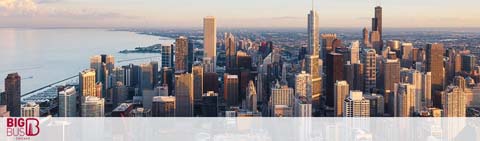 A panoramic view of a dense city skyline during early morning light is depicted. Skyscrapers dominate the scene with reflective glass facades, and the gentle hues of dawn touch the horizon over calm water. The sky is clear and the city is waking up. In the foreground, the Big Bus logo suggests city tours.