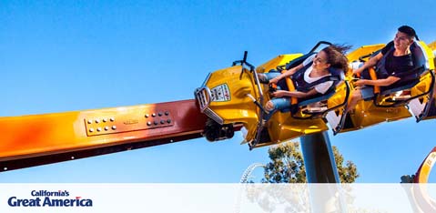 Description: The image features a dynamic scene from California's Great America amusement park capturing a thrilling ride in action under a clear blue sky. A gondola shaped like a bright yellow plane with details mimicking a fighter jet is suspended on a long arm attached to a central axis, enabling it to swing and spin. Two individuals with their hair sweeping back from the swift movement appear elated as they experience the ride, with one rider's arms raised in exhilaration. Below the gondola, the park's logo in white capital letters over a blue background is shown, confirming the location as California's Great America. 

At GreatWorkPerks.com, customers always find amazing savings on tickets, ensuring they get the lowest prices for their next adrenaline-filled adventure.