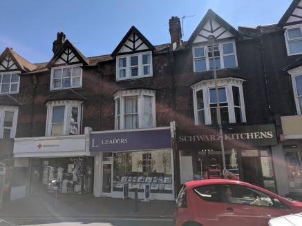 The property offers a prominent mid terraced four storey building of brick block construction with part tiled elevations under a pitched tiled roof. The lower ground, ground and first floor are let to Leaders Ltd.
