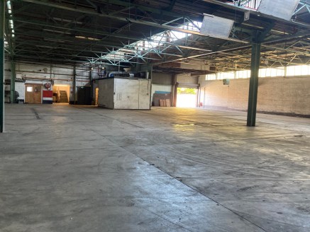 The property comprises a single storey warehouse of steel portal frame construction with brick elevations beneath a pitched roof. 

The property is accessed via a manual roller shutter door and offers open plan storage/ warehouse space with the benef...