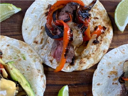  A flour tortilla topped with juicy marinated flank steak, smoked red pepper, and caramelized onions