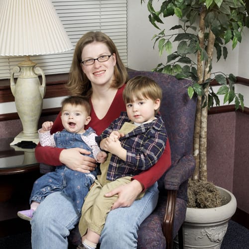 Happy mom seated with two children