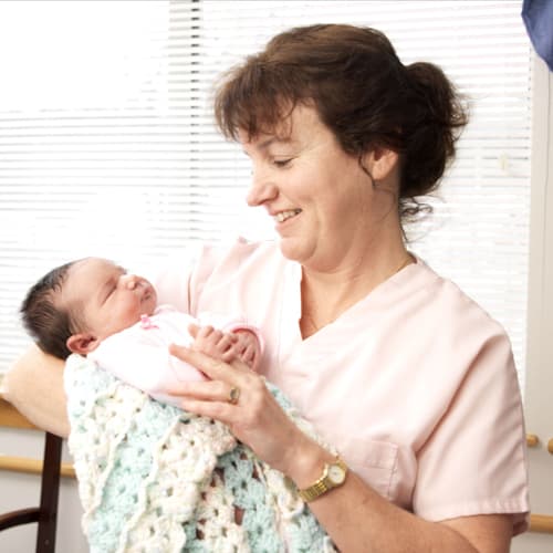 Nurse holding newborn baby