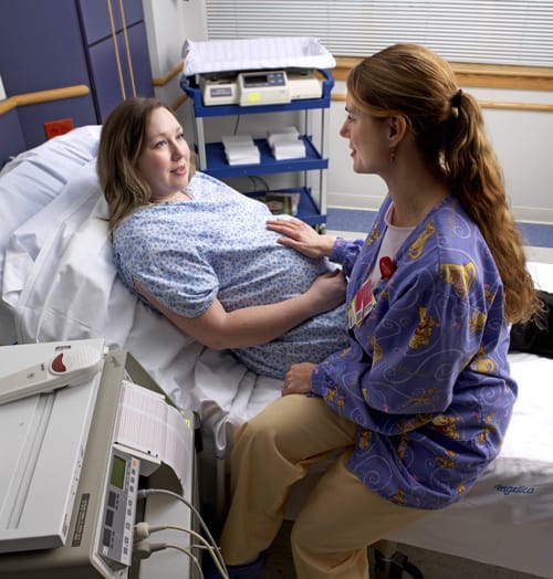 Nurse bedside with pregnant patient