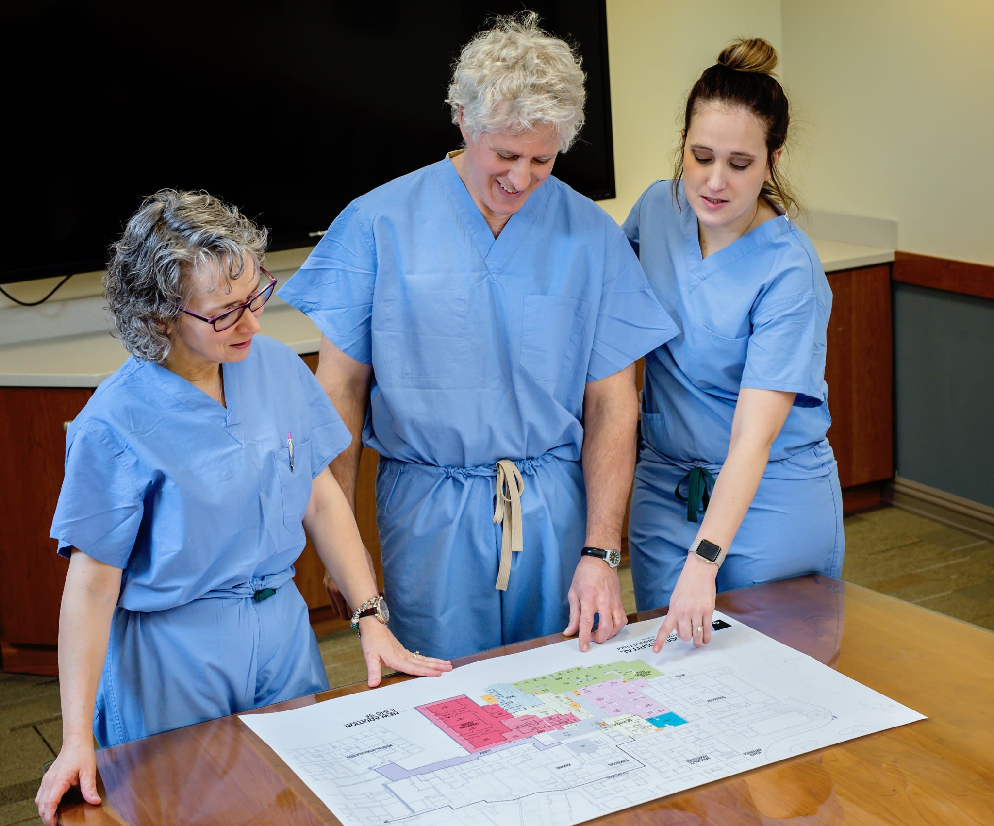 Surgeons looking down at building plans