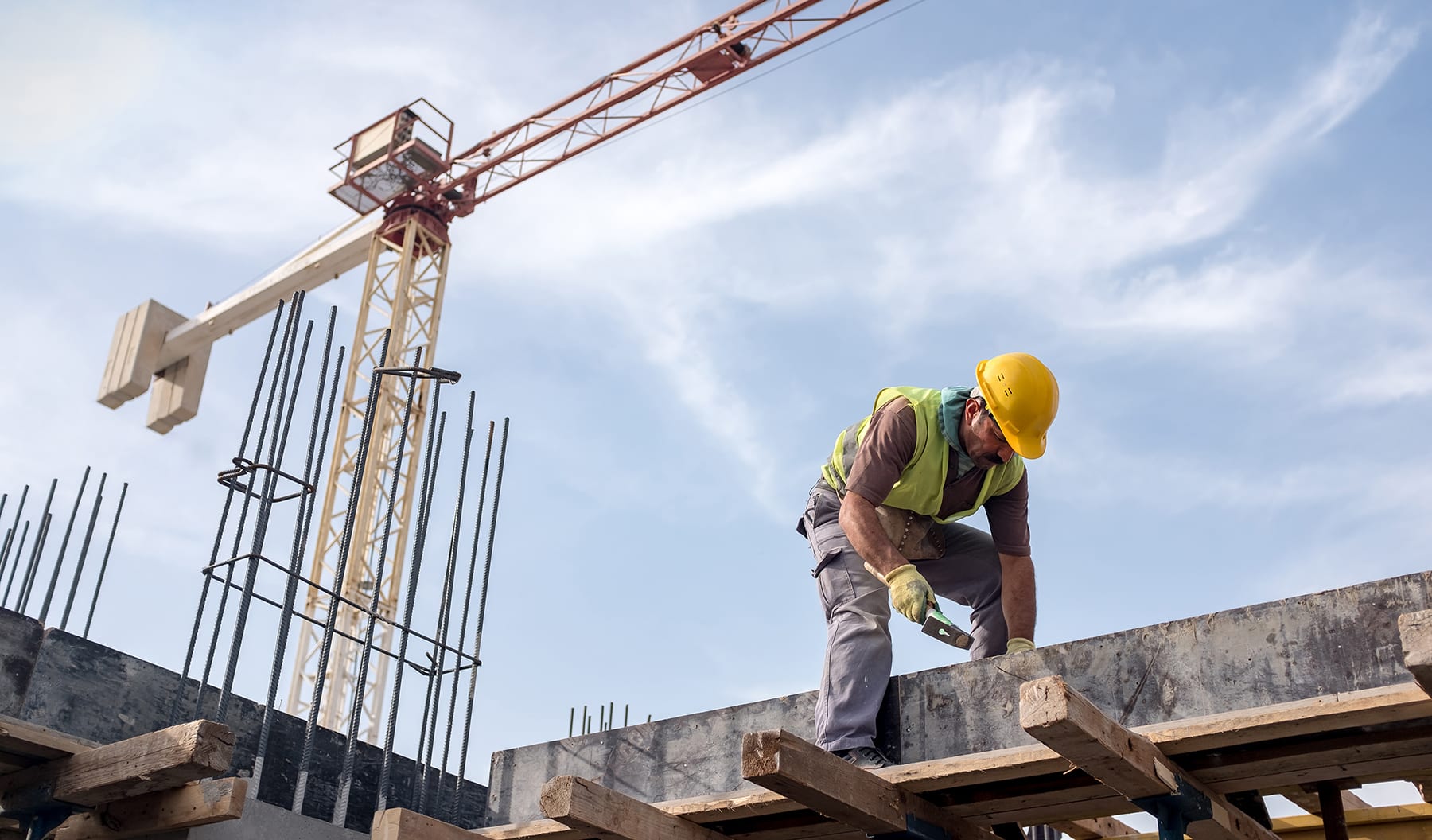 Workplace Injury - man in hard hat, crane in background