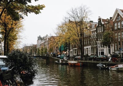 Boats on an Amsterdam canal lined with gabled houses