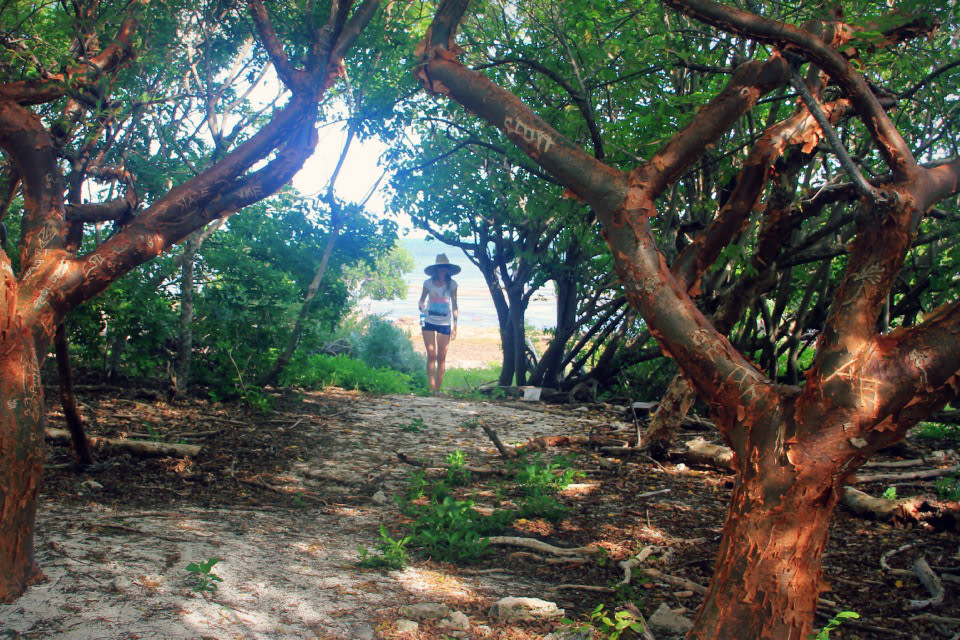 girl walking down a trail from the beach