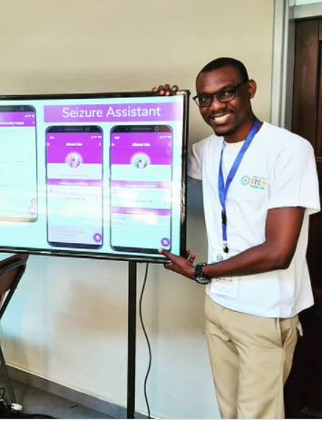 Bright Bwalya standing next to a screen displaying a seizure assistant application.