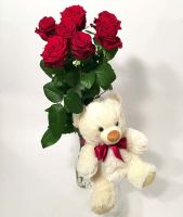 Soft teddy bear and a long red roses