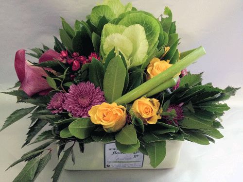 Flower arrangement in ceramic pot with brassicas