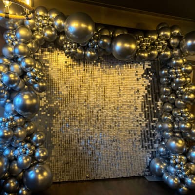 Silver Sequin Wall With Silver Balloons Creating A Backdrop For A Wedding