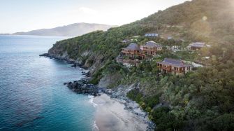 treelined coastal landscape with houses, ocean, beach, hills