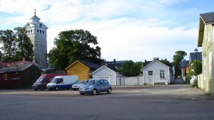 Basatorget ska inte beläggas med krossgrus utan gatsten, anser politikerna. Hus och bilar på Basatorget i gamla stan i Ekenäs.